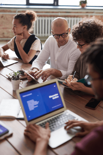 photo-of-people-working-near-brown-wooden-table-3184162